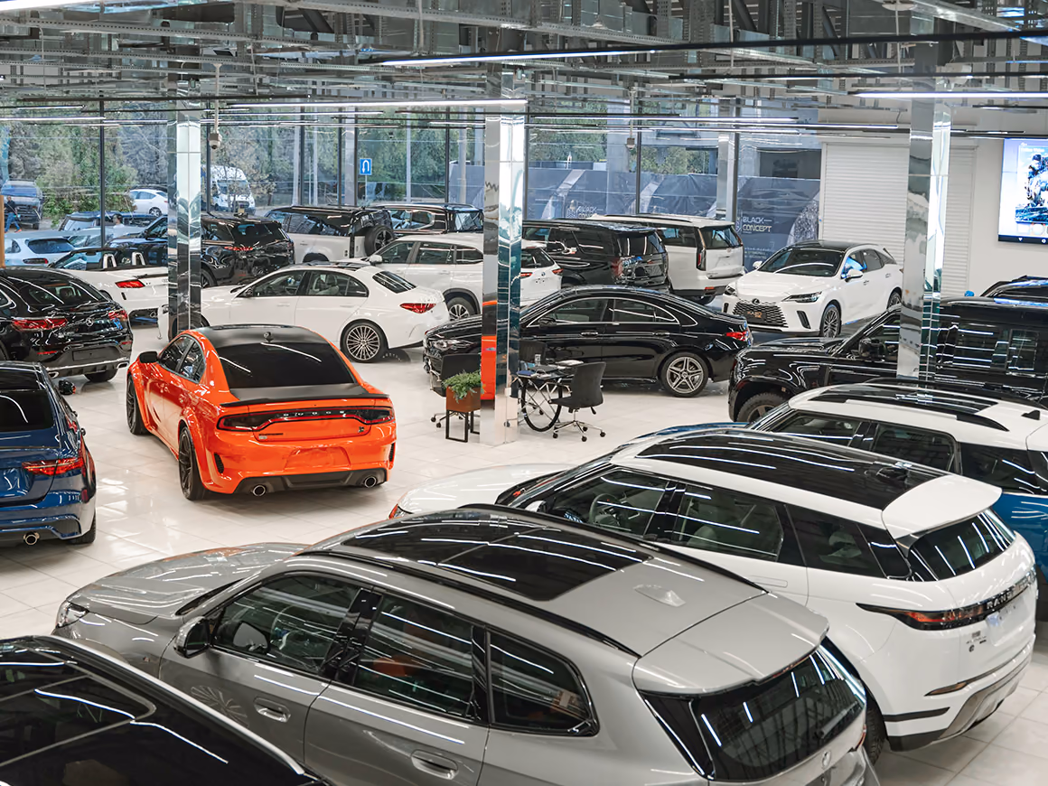 Ausstellungshalle eines Autohauses mit vielen geparkten Neu- und Gebrauchtwagen