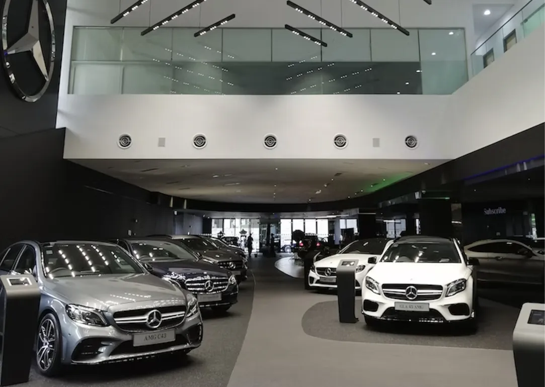 Eine Fotograf in einem Autohaus, mehrere Neuwagen sind zu sehen
