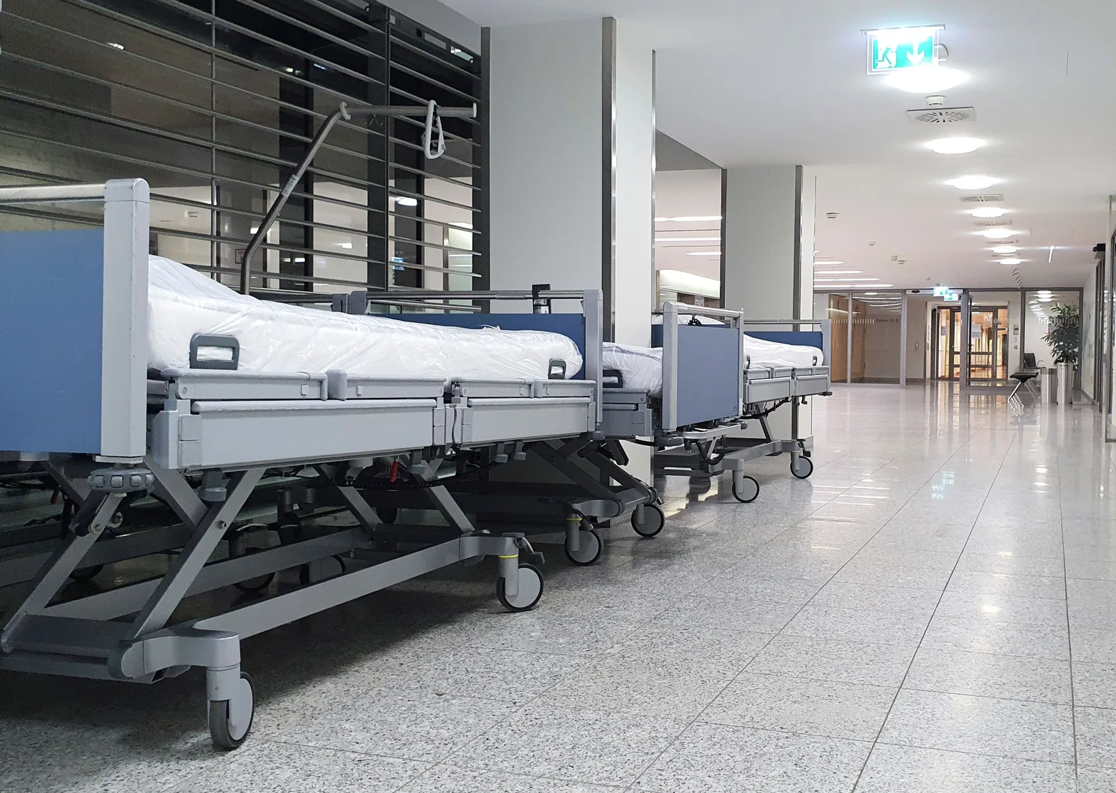 Klinikbetten stehen in einem hellen Krankenhausflur